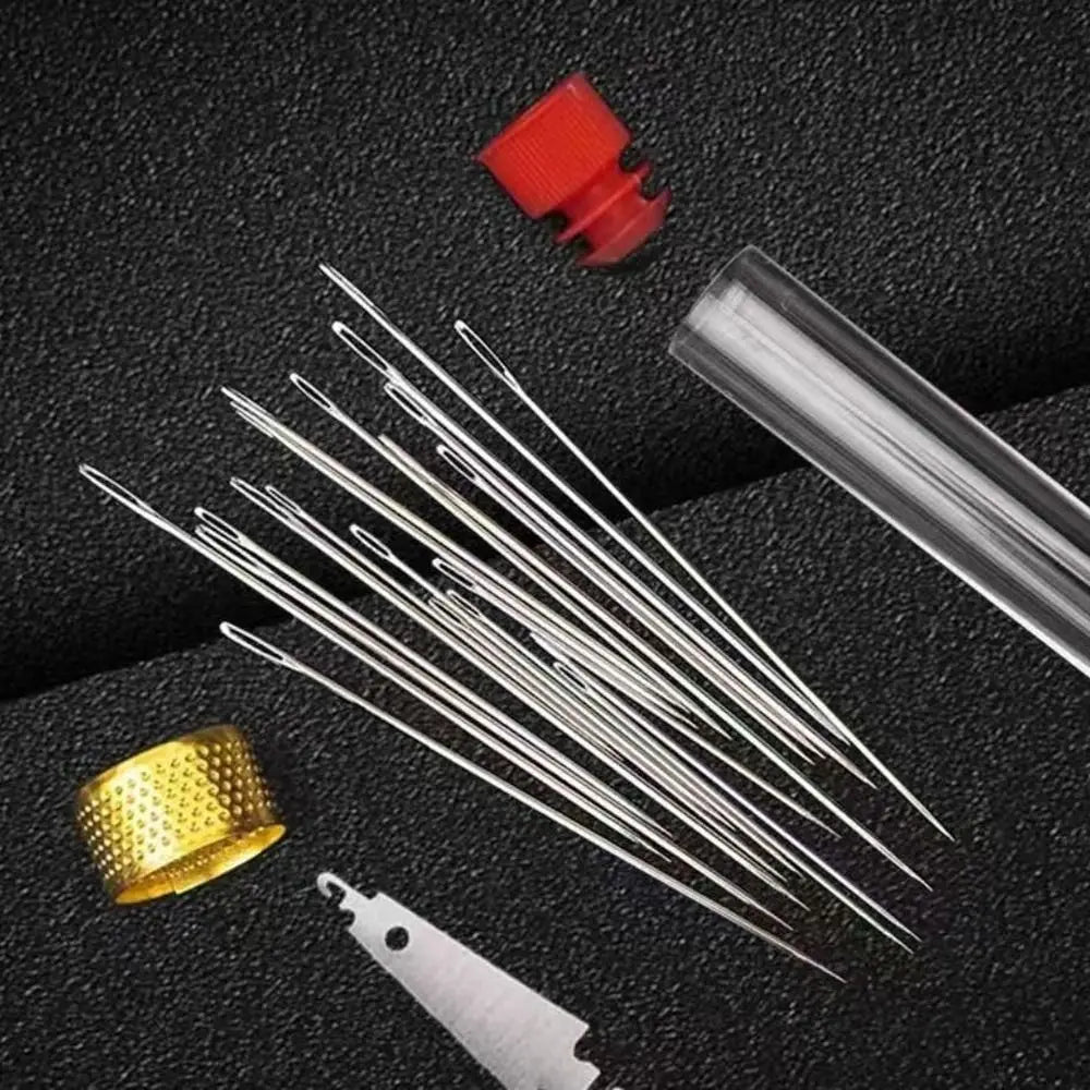 A collection of premium stainless steel sewing needles and a red tool on a dark surface.