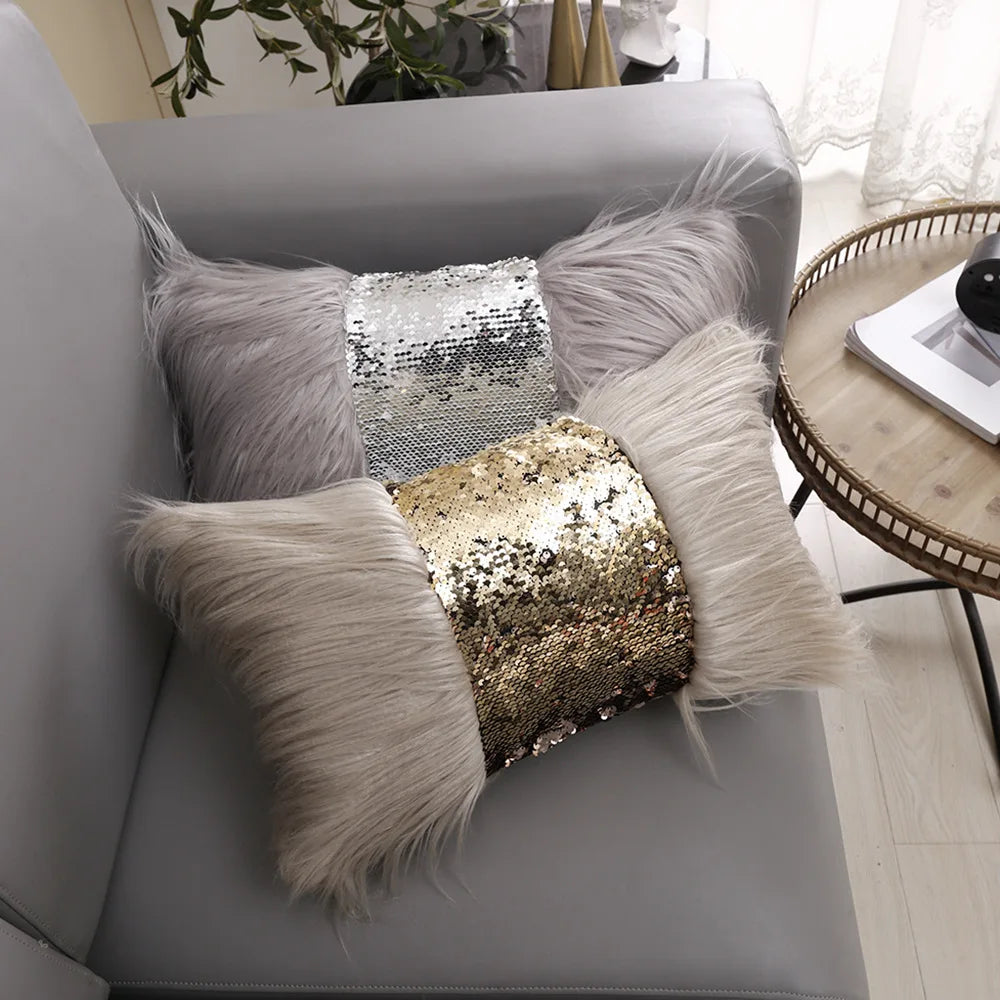 A gray sofa features three decorative cushions with silver and gold sequin fabric and fluffy fur trim.