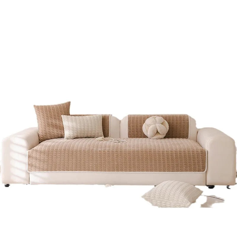 A beige non-slip sofa cover with a quilted light beige fabric and decorative pillows.