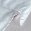 A close-up of a white ice silk cooling quilt fabric folded and draped.