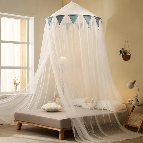 A sheer white mosquito net canopy is draped over a bed and window, creating a soft, airy enclosure.