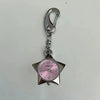 Silver keychain featuring a pink-faced pocket watch with a star-shaped body.