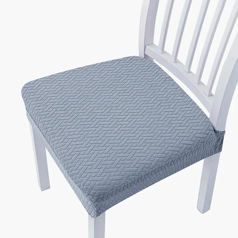 A light blue quilted seat cover for a white wooden bar or dining chair.