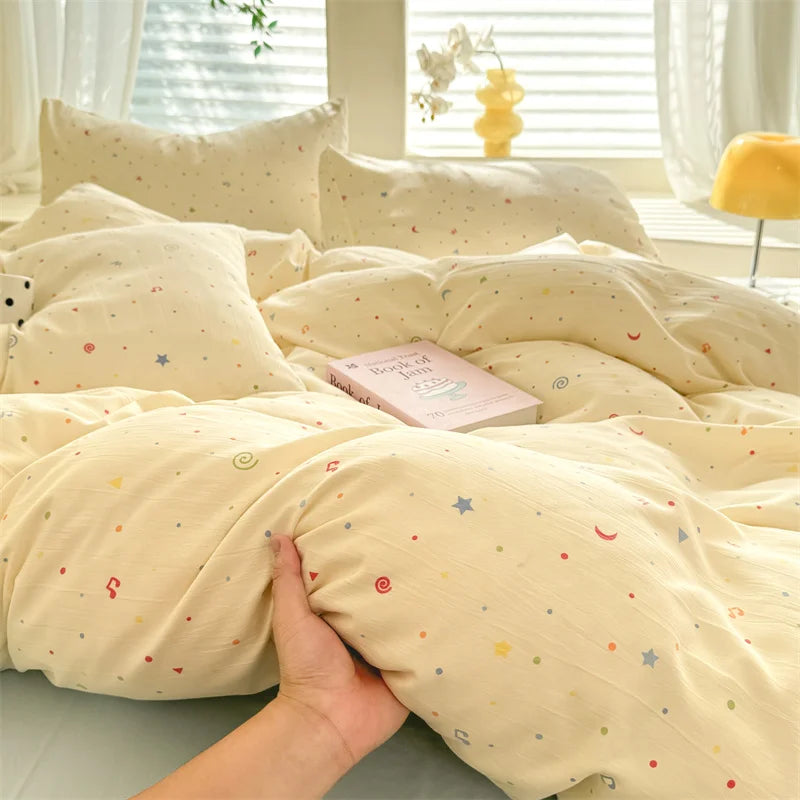A light yellow duvet set with a cute dog print featuring small stars and moons, displayed on a bed.