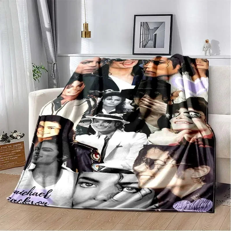 A printed flannel blanket featuring a collage of pop music artists' faces in black and white tones.