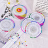 A collection of colorful pearl head pins for sewing and crafting displayed on a white surface.