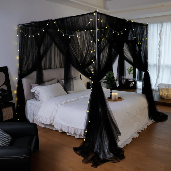 Elegant mosquito net bed canopy with black sheer fabric and warm string lights draped over a white bed.