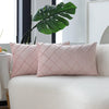 Two pink quilted velvet decorative pillow covers resting on a white sofa.