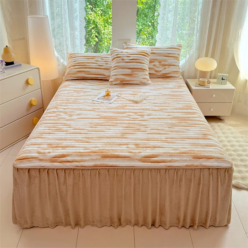 A plush bed skirt linen set featuring a striped peach and cream duvet cover on a light wood bed.