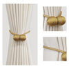 Gold magnetic ball curtain tiebacks shown in various close-up and full view against a light fabric background