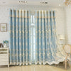Light blue floral curtains with gold trim hanging in a bright room.