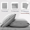 A set of four gray microfiber bed sheets and two pillowcases are displayed on a bed.