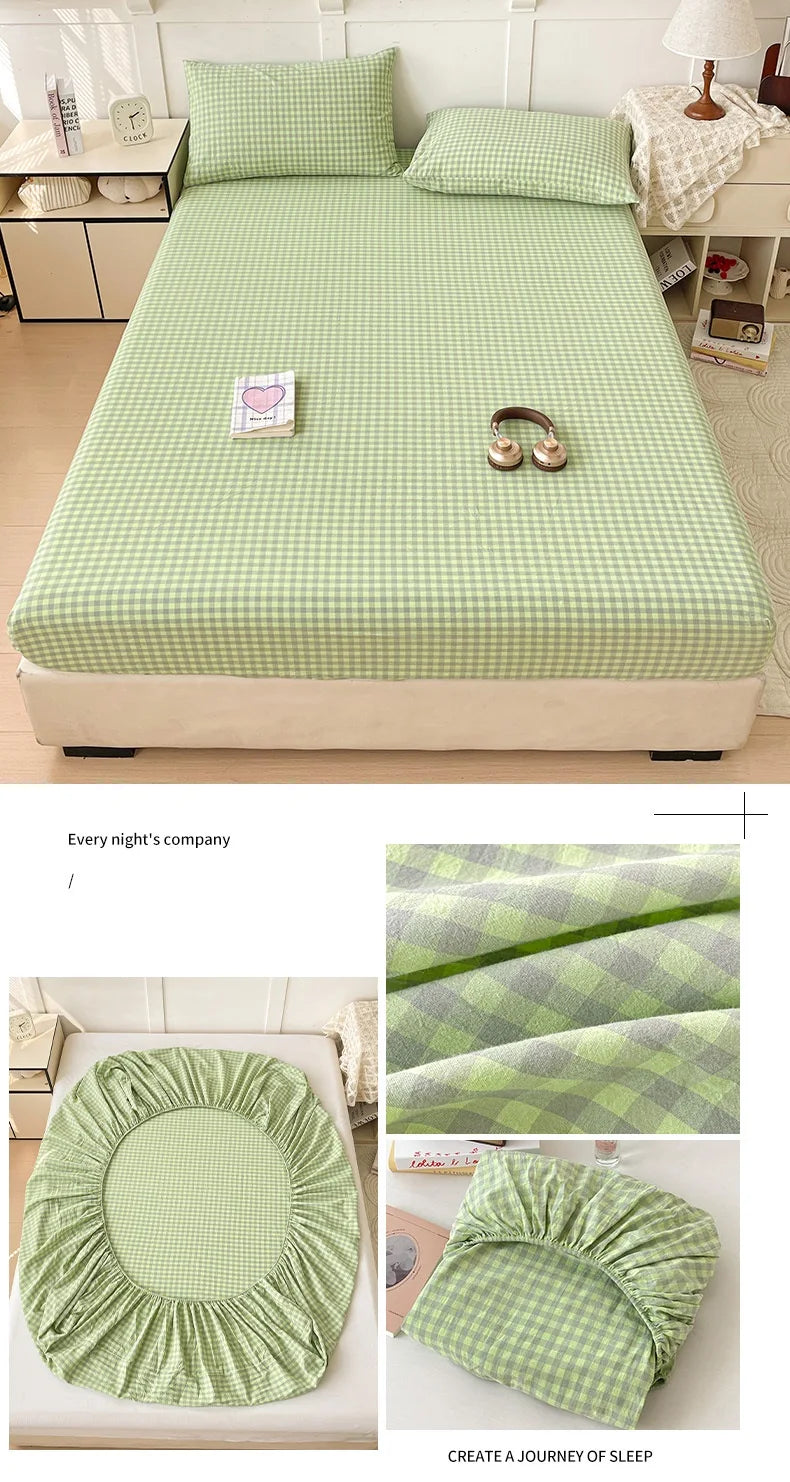 A light green checkered fitted sheet is displayed on a bed, alongside ruffled pillow covers and a folded sheet.