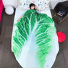 A green leafy pattern plush throw blanket is draped over a white surface.