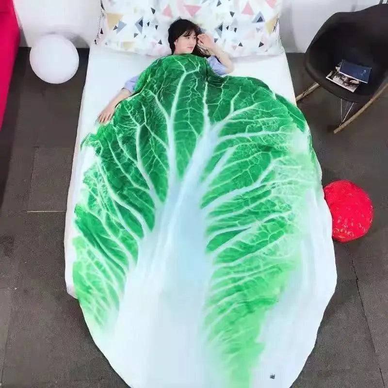 A green leafy pattern plush throw blanket is draped over a white surface.
