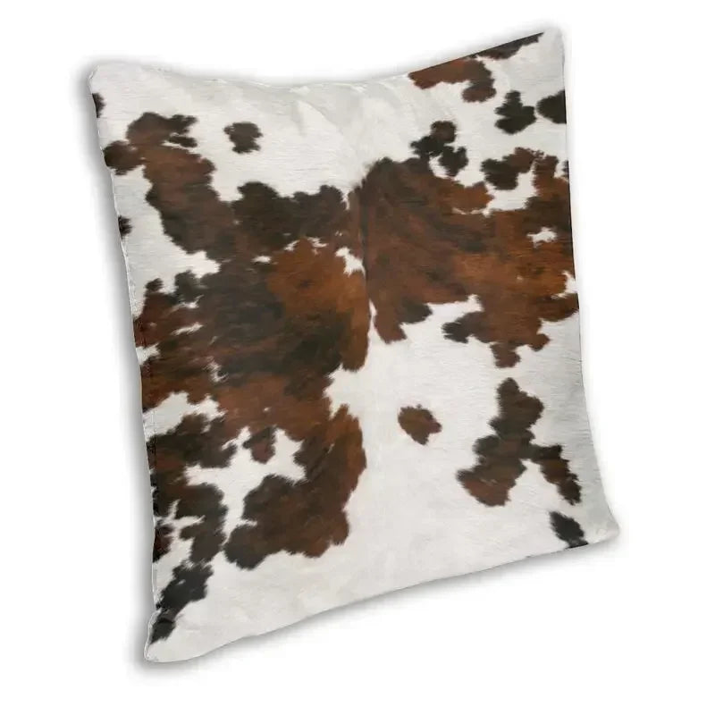 A square cushion cover featuring a brown and white cowhide print.