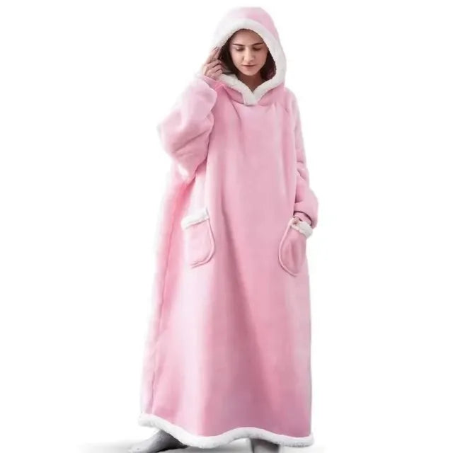 A woman wearing a pink oversized flannel blanket pyjama set with a hood.