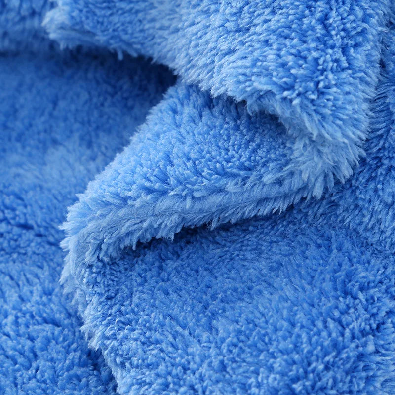 A close-up of a bright blue coral fleece microfiber cleaning cloth folded and textured.