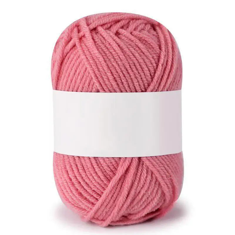 A skein of pink soft milk cotton knitting yarn coiled into a ball.