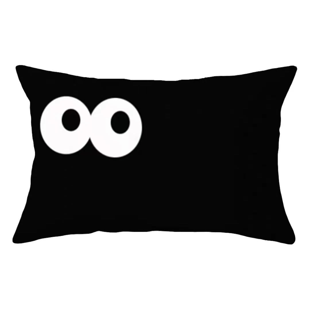 A black pillow cover with two white circular designs on the front.