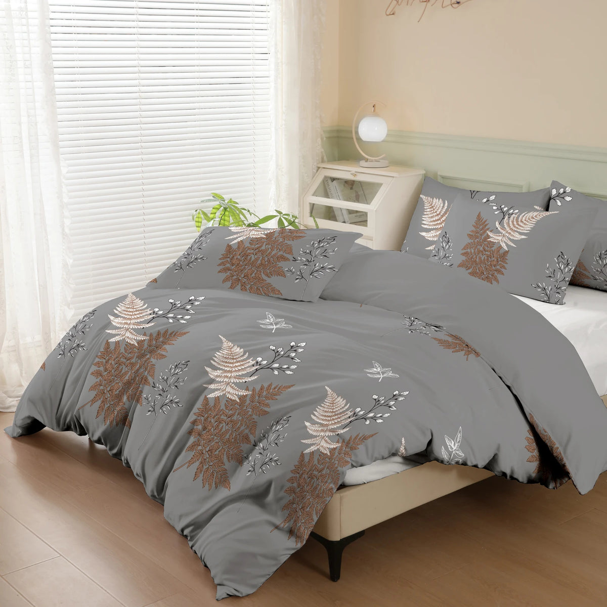 Gray duvet cover set featuring a botanical print of brown and gray foliage on a bed.