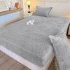 Gray jacquard weave fitted sheet bedding on a bed with a bedside lamp.