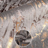Close-up of a gray velvet cushion cover with abstract gold foil leaf patterns.