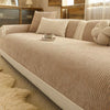 A beige striped chenille sofa cover displayed on a light-colored sofa with natural wood accents and sheer curtains.
