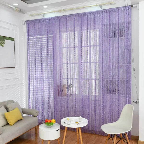 Purple glitter fringe door curtain hanging in a room with white trim and wooden floor.