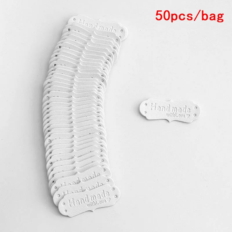 A stack of 50 PU leather embossed tags in white, showing various designs for handmade crafting.