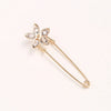 A delicate gold adjustable pearl brooch shaped like a flower with clear stones.