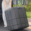 A large gray fabric storage bag with a grid pattern is being held by a person outdoors.