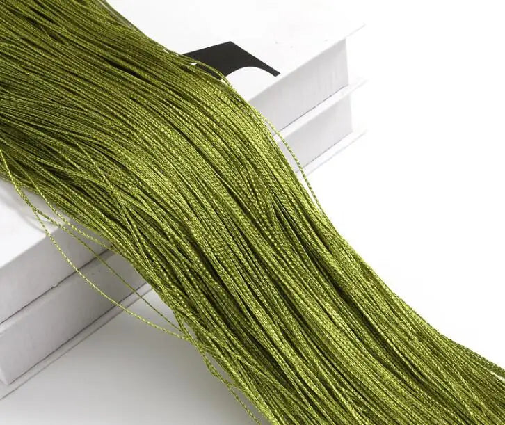 A close-up of a long, bright olive green thread curtain tie-back for doors and windows.