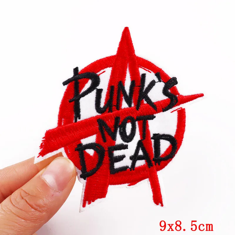 Red embroidery patch featuring the text PUNKS NOT DEAD on a white background