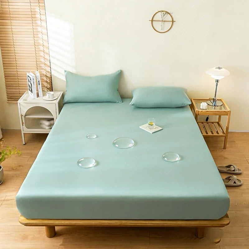 A light blue waterproof mattress and bed protector sheet is laid out on a wooden bed frame in a bright room.