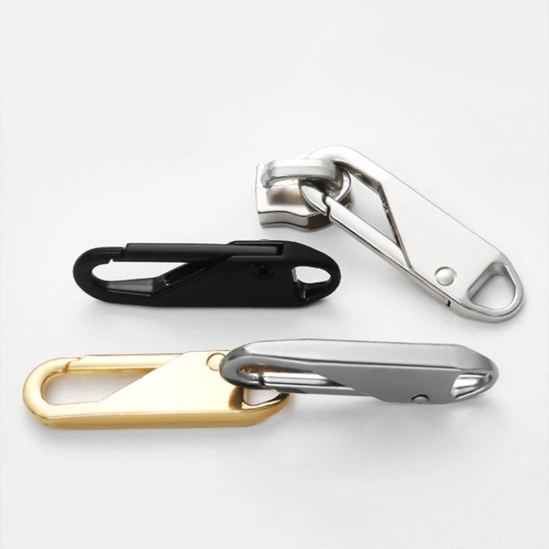 A set of three zipper pulls in silver, black, and gold finishes for bags and garments.