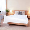 A white high-stretch elastic box spring cover is displayed on a wooden bed frame with decorative pillows.