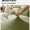 Close-up of a textured olive green jacquard sofa cover fabric showing high elasticity and woven branch patterns.