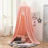 A pink princess hanging bed canopy for kids with a white feather decoration and soft fabric draping.