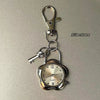 A silver quartz pocket watch is attached to a metal keychain with a clasp.