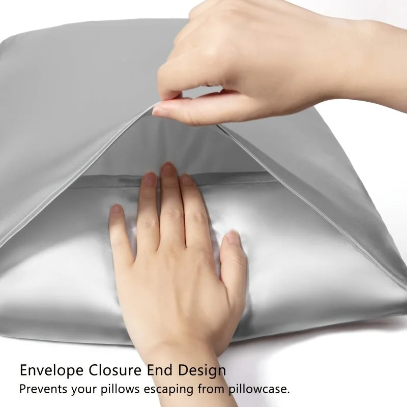 Hands are closing an envelope closure end design on a satin pillowcase to prevent pillows from escaping.