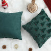 A teal velvet throw pillow with a green patterned cover rests on white faux fur with festive holiday decor.