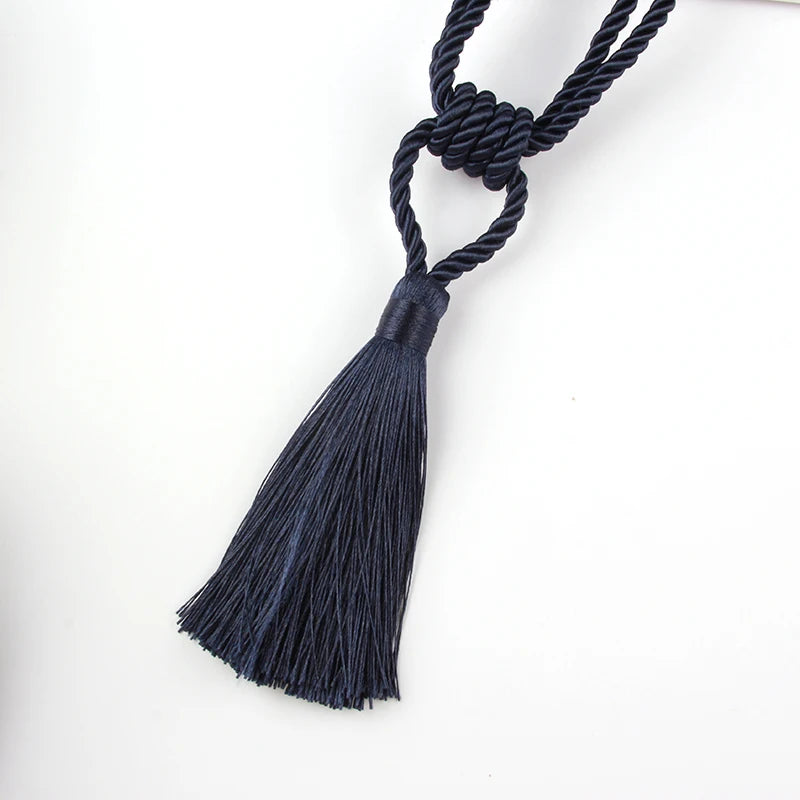 A dark navy blue elegant curtain tieback with a braided cord and long tassel.