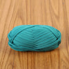A ball of teal flat thread yarn for crafting and sewing resting on a wooden surface.