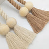 Two hand-woven wooden curtain tiebacks in natural beige and cream tones displayed on a white background.