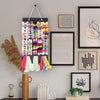 A display of colorful hair clips and accessories hanging on a black hanger against a light gray wall.