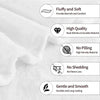 A close-up view of a white, fluffy flannel throw blanket showing various quality features like softness and durability.