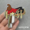 Embroidered iron-on patch featuring a stylized brown and red cowboy figure with a star design