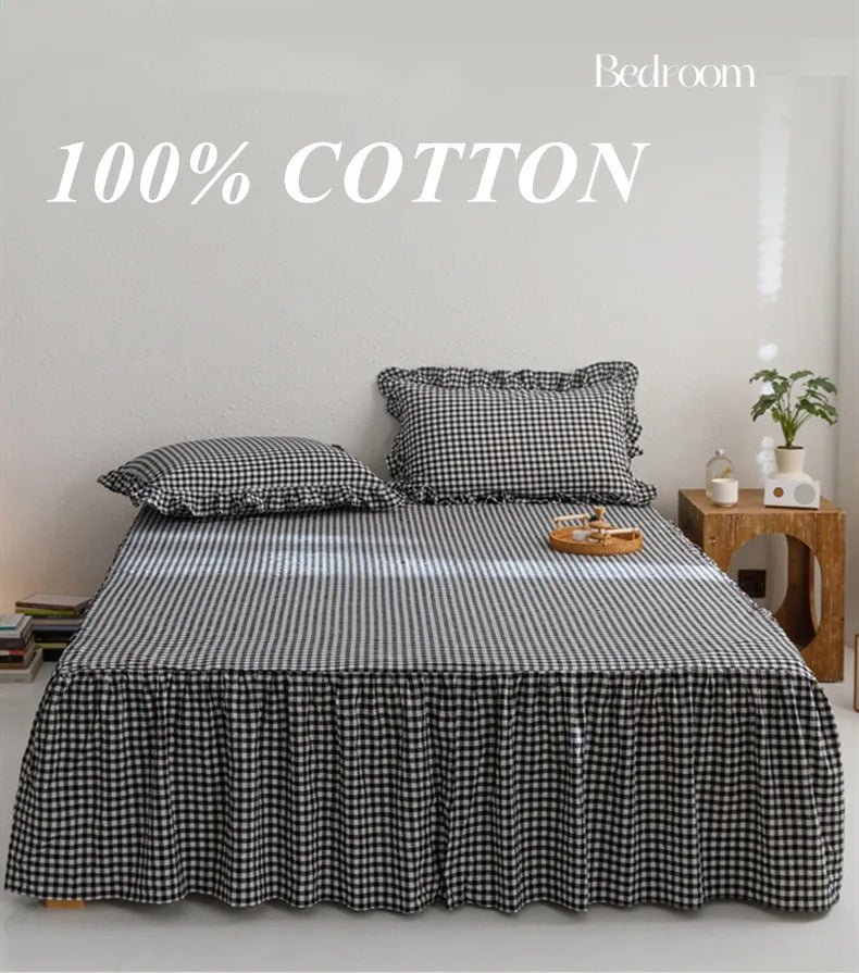 A black and white plaid cotton bed skirt cover with a matching pillow on a bed in a bright room.