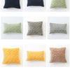 A grid of nine plaid cushion covers in various shades of blue, green, yellow, and beige.